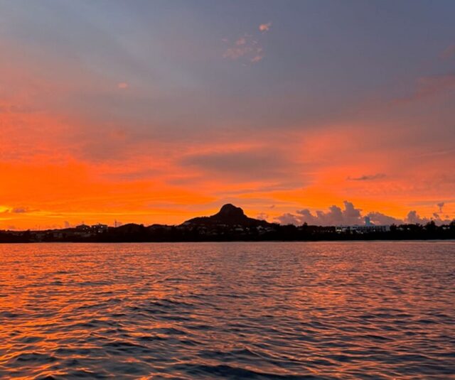 夕日に染まる海から望む、伊江島のシンボル「城山（タッチュー）」の美しいシルエット