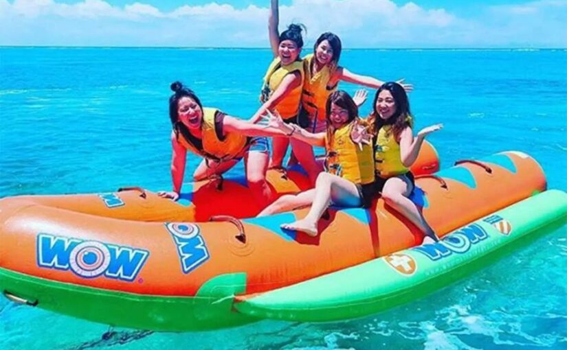 水納島でマリンスポーツを満喫。笑顔でバナナボートに乗る観光客